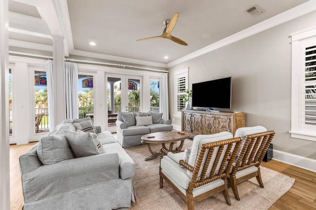 living room with crown molding, french doors, ceiling fan, and light wood-type flooring