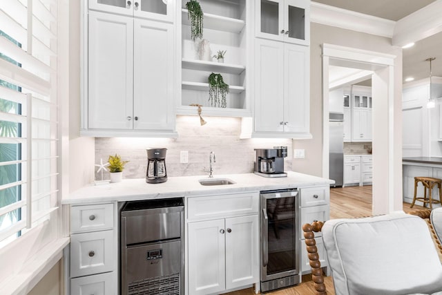 kitchen featuring stainless steel fridge, white cabinetry, wine cooler, and ornamental molding