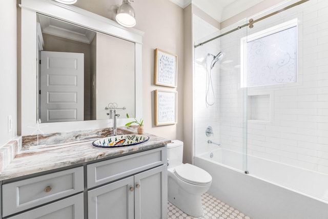 full bathroom with vanity, tiled shower / bath combo, toilet, and crown molding