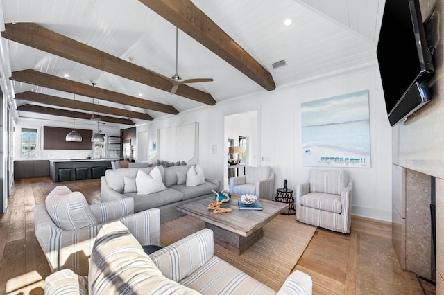 living room with lofted ceiling with beams, light hardwood / wood-style flooring, and ceiling fan