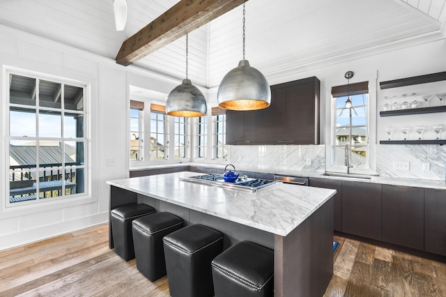 kitchen featuring hardwood / wood-style floors, sink, dark brown cabinets, a kitchen island, and stainless steel appliances