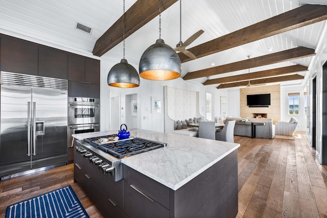 kitchen with decorative light fixtures, a center island, stainless steel appliances, and plenty of natural light