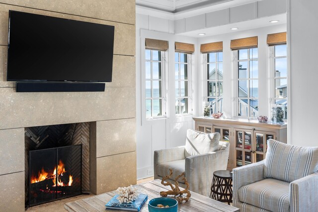 living room featuring a wealth of natural light, crown molding, and tile walls