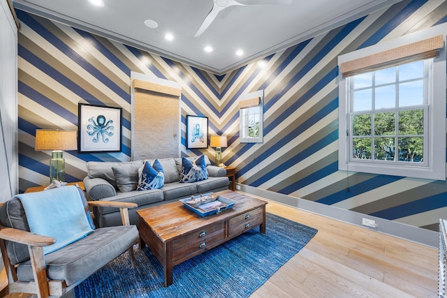 living room with hardwood / wood-style floors, ceiling fan, and crown molding