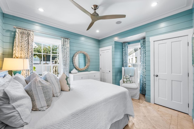 bedroom featuring ceiling fan, ornamental molding, and wooden walls