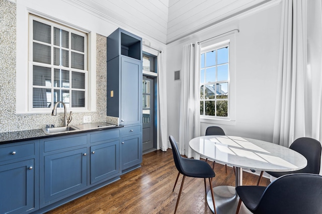 kitchen with backsplash, ornamental molding, blue cabinets, sink, and dark hardwood / wood-style floors