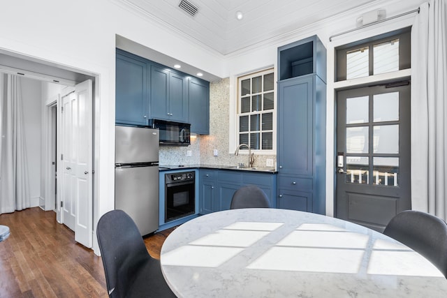 kitchen featuring black appliances, dark hardwood / wood-style floors, a healthy amount of sunlight, and blue cabinetry