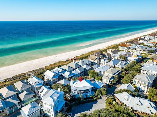 birds eye view of property with a water view and a beach view