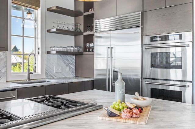 kitchen featuring appliances with stainless steel finishes, backsplash, a healthy amount of sunlight, and sink