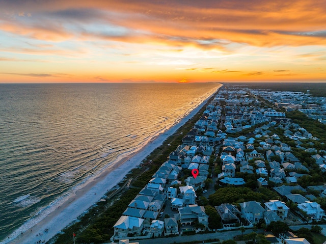 aerial view at dusk with a view of the beach and a water view