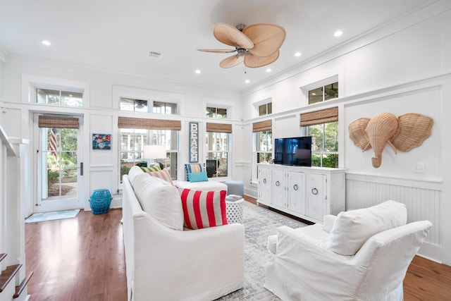 living room featuring hardwood / wood-style flooring, crown molding, ceiling fan, and a healthy amount of sunlight