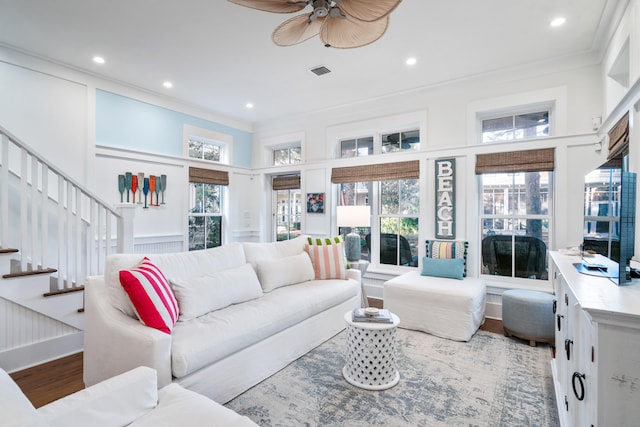 living room with hardwood / wood-style floors, ceiling fan, ornamental molding, and a wealth of natural light