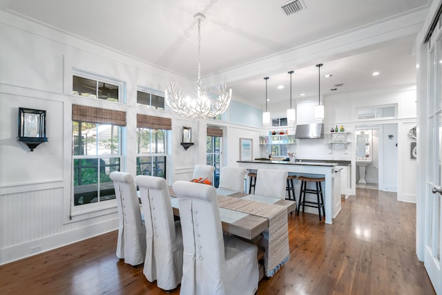 dining room featuring a notable chandelier, dark hardwood / wood-style flooring, and crown molding