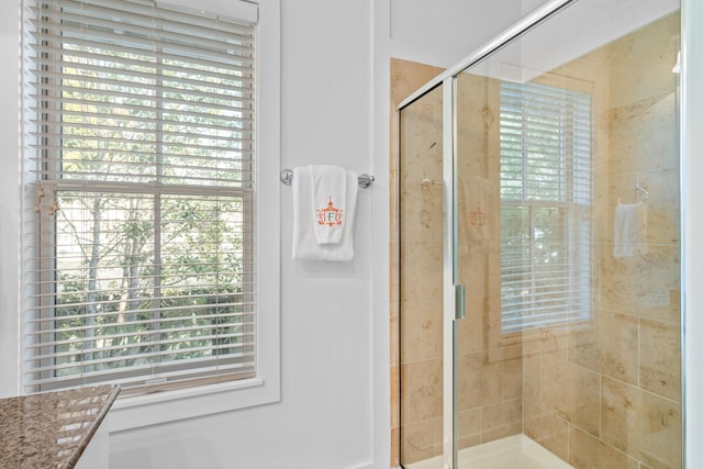 bathroom with an enclosed shower and a healthy amount of sunlight