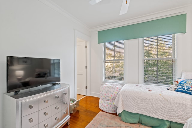 bedroom featuring hardwood / wood-style flooring, ceiling fan, and ornamental molding