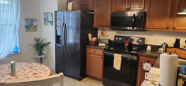 kitchen with black electric range oven and fridge with ice dispenser