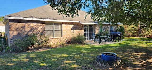 rear view of house with a lawn and a patio