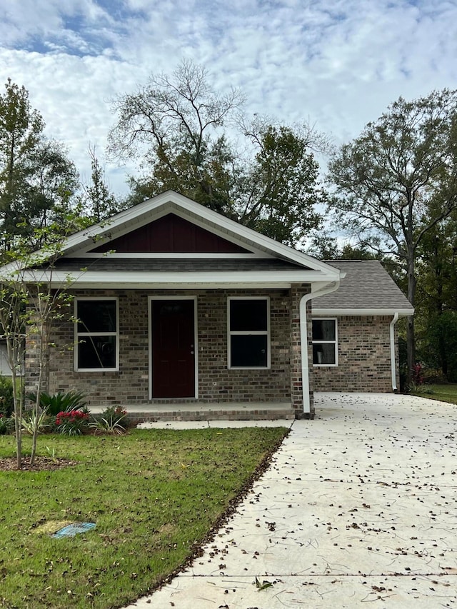 view of front of house with covered porch and a front lawn