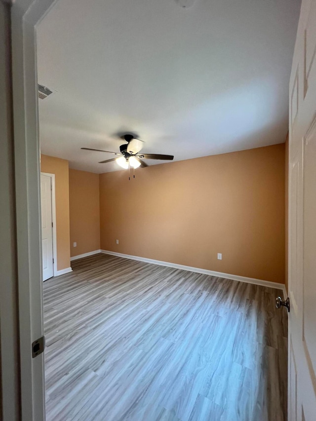 empty room with light hardwood / wood-style flooring and ceiling fan