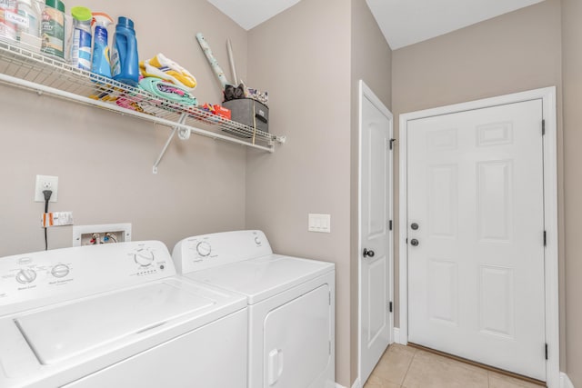 laundry room with washing machine and dryer and light tile patterned flooring