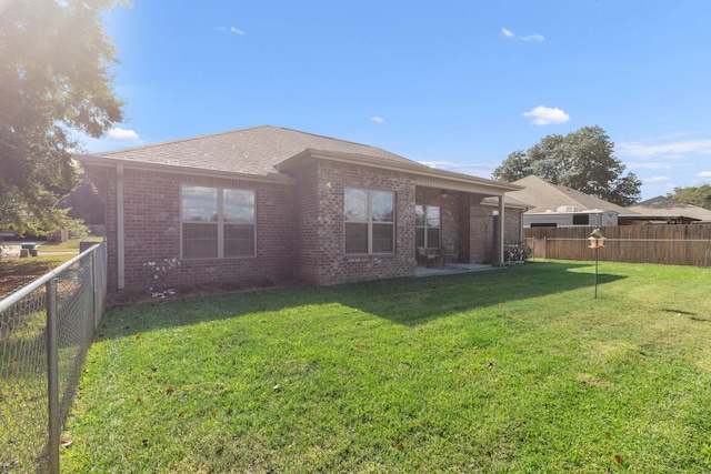 rear view of property with a lawn and a patio