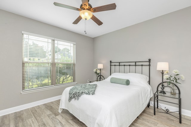 bedroom with light hardwood / wood-style floors and ceiling fan