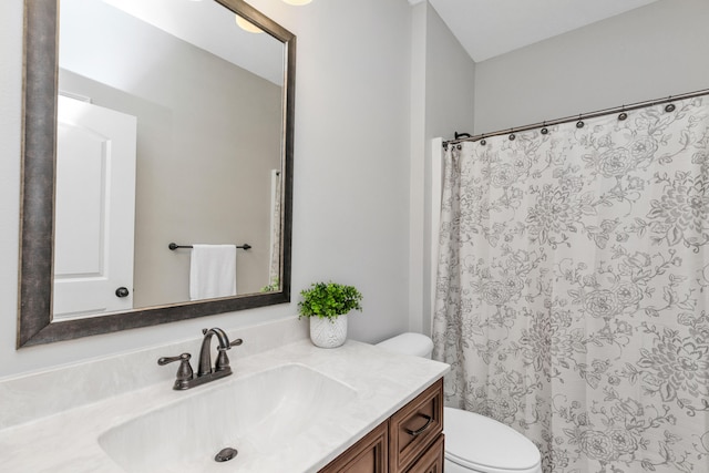 bathroom featuring curtained shower, vanity, and toilet