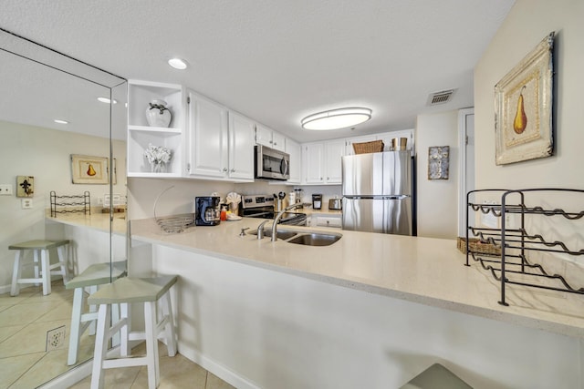 4100 E Co Hwy Unit 30A 1102 # 1102, Santa Rosa Beach, FL 32459 - kitchen with stainless steel appliances, a peninsula, open shelves, light tile patterned floors, and white cabinetry