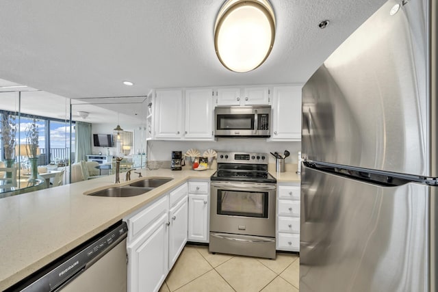 4100 E Co Hwy Unit 30A 1102 # 1102, Santa Rosa Beach, FL 32459 - kitchen featuring appliances with stainless steel finishes, a sink, light tile patterned flooring, white cabinets, and a textured ceiling