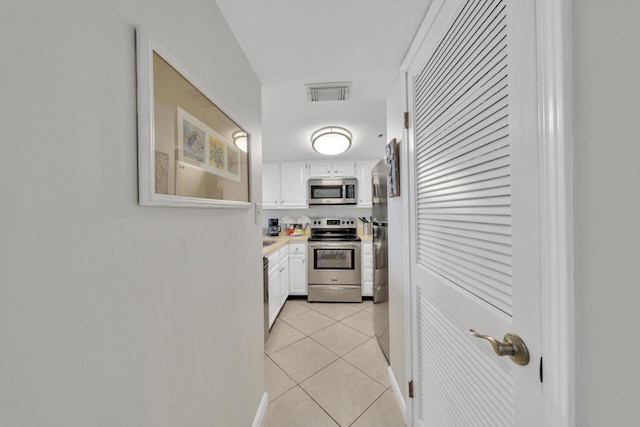 4100 E Co Hwy Unit 30A 1102 # 1102, Santa Rosa Beach, FL 32459 - kitchen featuring appliances with stainless steel finishes, white cabinetry, light tile patterned flooring, and light countertops