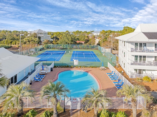 view of swimming pool with tennis court and a patio area