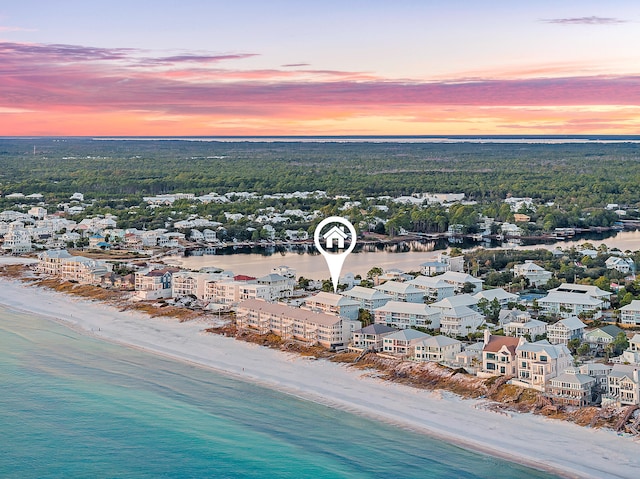 aerial view at dusk with a beach view and a water view