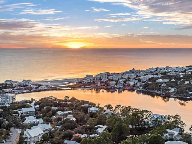 aerial view at dusk featuring a water view