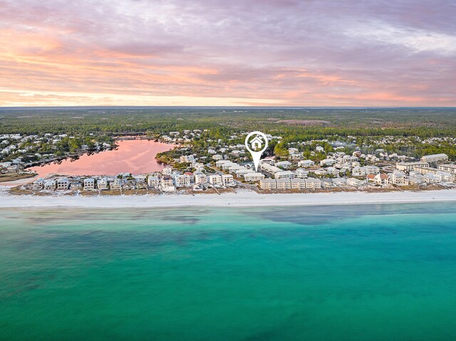 aerial view at dusk with a view of the beach and a water view