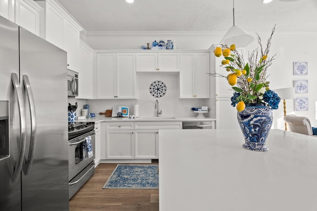 kitchen featuring stainless steel appliances, dark hardwood / wood-style flooring, pendant lighting, sink, and white cabinetry