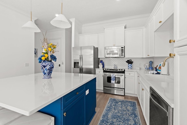 kitchen with stainless steel appliances, white cabinetry, pendant lighting, hardwood / wood-style floors, and blue cabinets