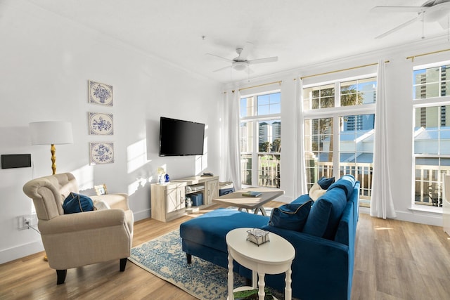 living room featuring ornamental molding, light wood-type flooring, and ceiling fan