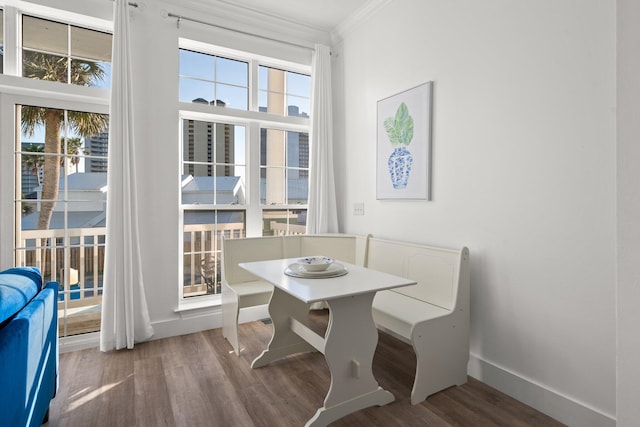 dining space featuring hardwood / wood-style floors, ornamental molding, and plenty of natural light