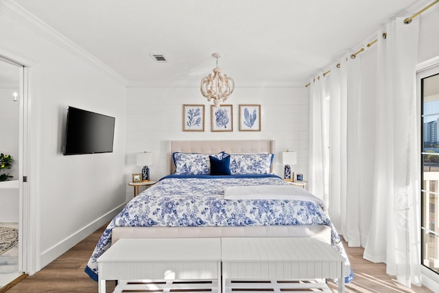 bedroom with hardwood / wood-style flooring, a chandelier, and crown molding