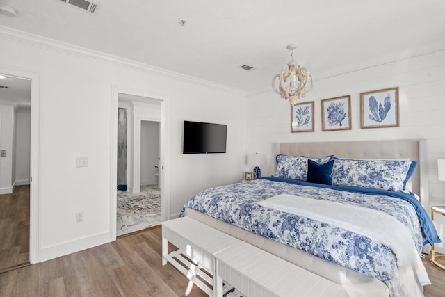 bedroom with an inviting chandelier, hardwood / wood-style flooring, and crown molding