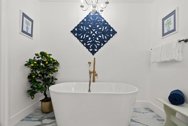 bathroom featuring a bath, an inviting chandelier, and crown molding