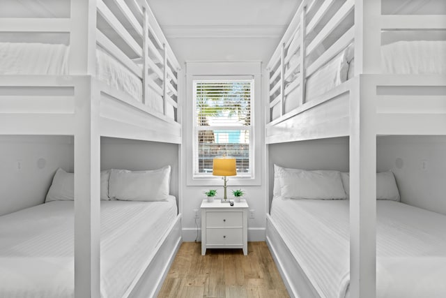 bedroom with crown molding and light hardwood / wood-style flooring