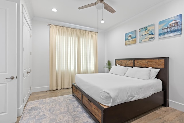 bedroom featuring hardwood / wood-style flooring, ceiling fan, and crown molding