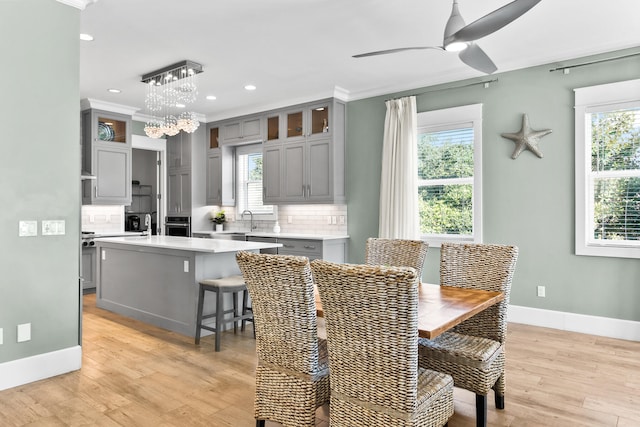 dining area featuring a wealth of natural light, light wood-type flooring, and ornamental molding