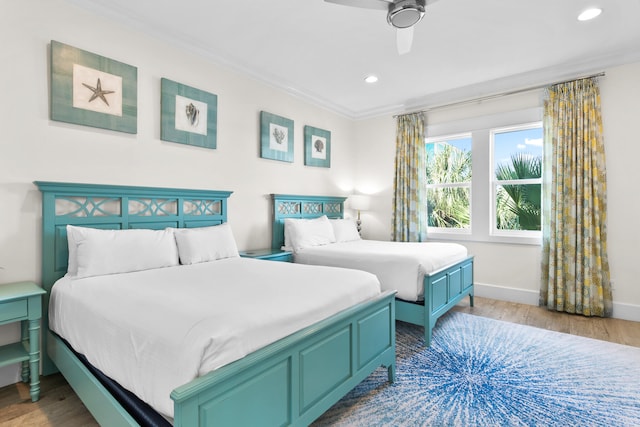 bedroom with light hardwood / wood-style floors, ceiling fan, and ornamental molding