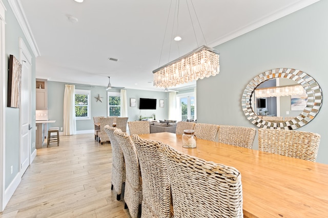 dining space with light hardwood / wood-style flooring and crown molding