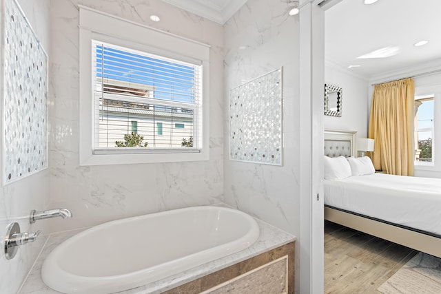 bathroom featuring wood-type flooring, ornamental molding, and tiled tub