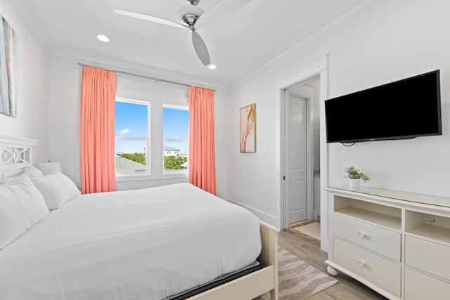 bedroom featuring ornamental molding, light wood-type flooring, and ceiling fan