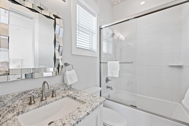 full bathroom with enclosed tub / shower combo, toilet, and vanity