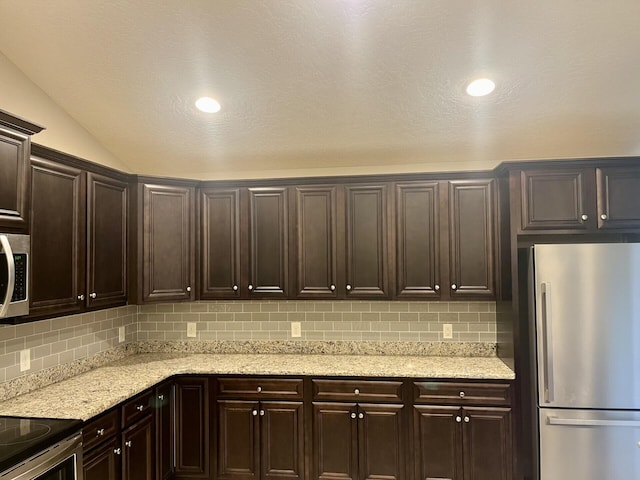 kitchen featuring appliances with stainless steel finishes, dark brown cabinetry, and backsplash